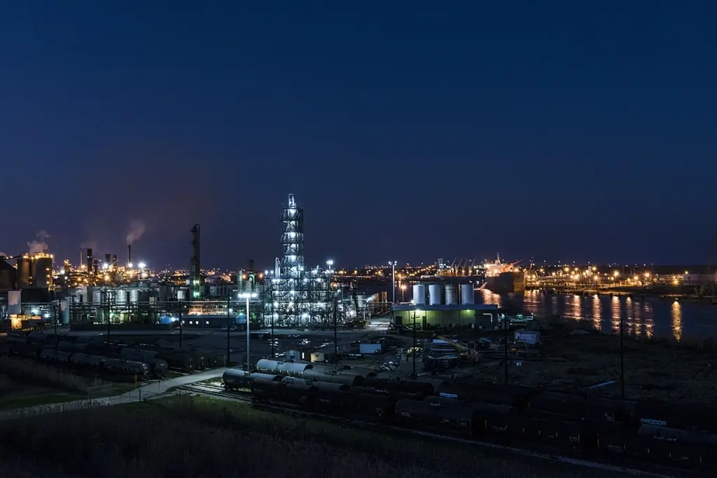 Vista noturna de uma planta industrial e refinaria com estrutura de engenharia complexa
