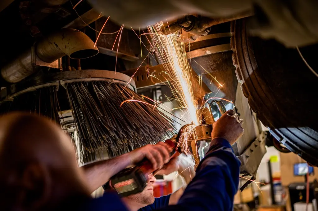 Técnico realizando reparo com faíscas de solda em um equipamento